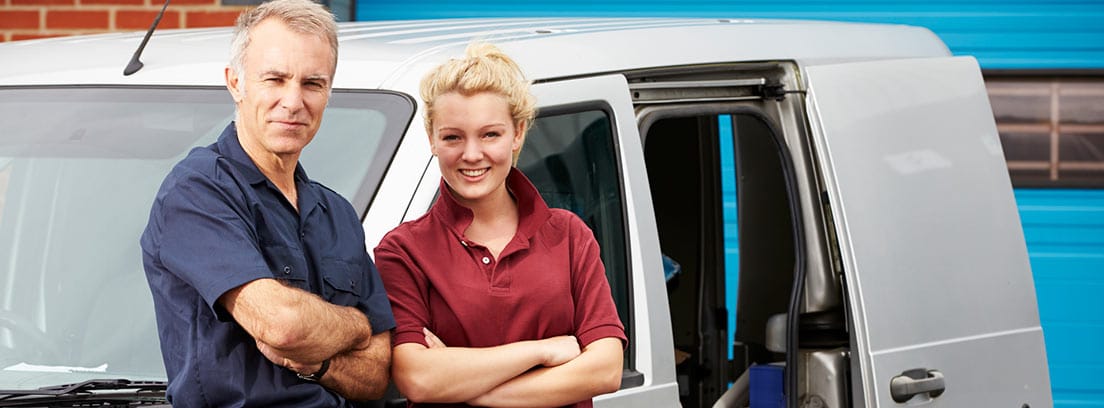 Hombre y mujer apoyados en una furgoneta de una empresa familiar