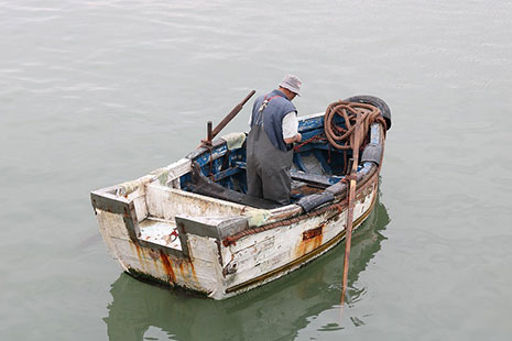 Pescador montando en una pequeña barca