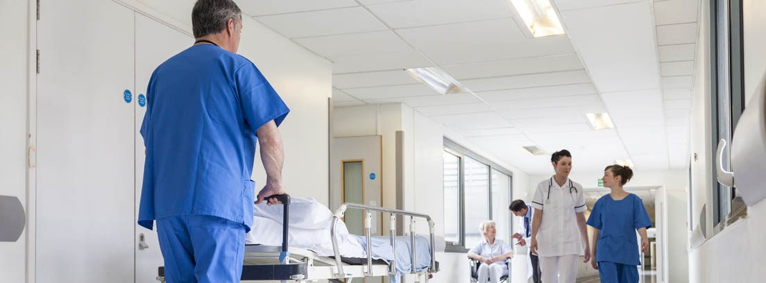 Enfermero empuja una camilla por el pasillo de un hospital