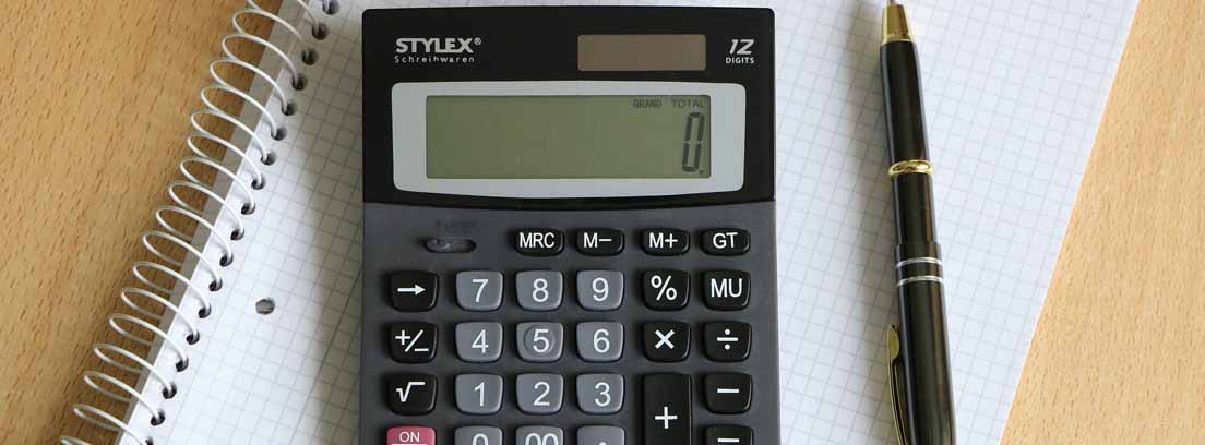 Vista cenital de una mesa con un cuaderno, un boli y una calculadora