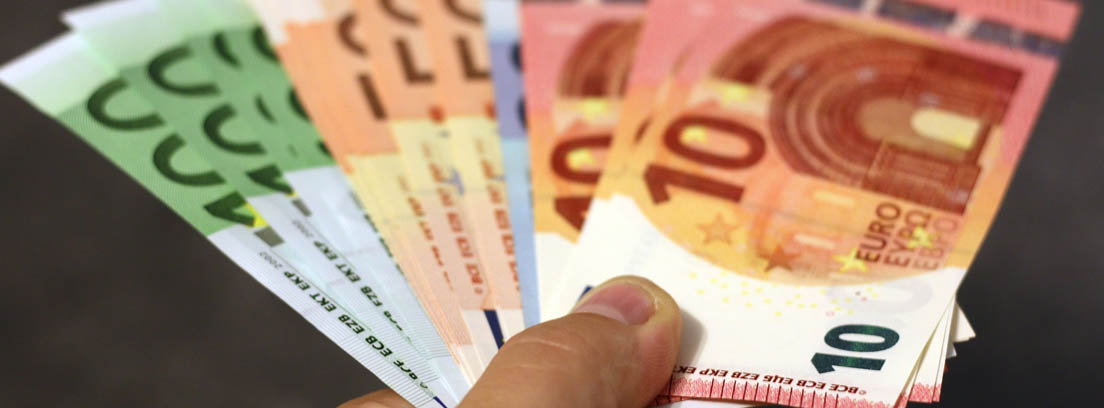 mano mostrando varios billetes de euro