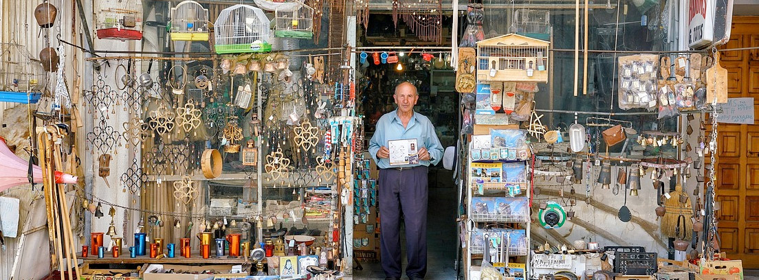Hombre en una tienda antigua realizando un contrato de traspaso de negocio