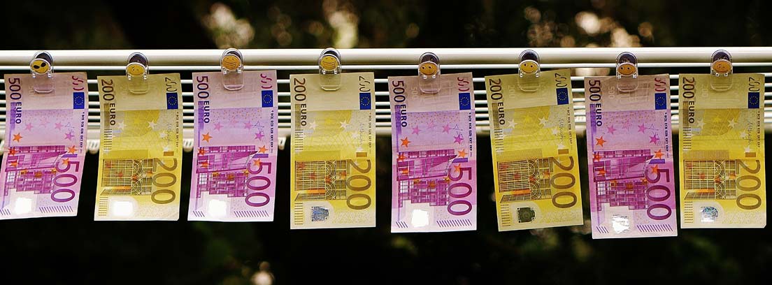 Billetes de euro colgados con pinzas de una cuerda