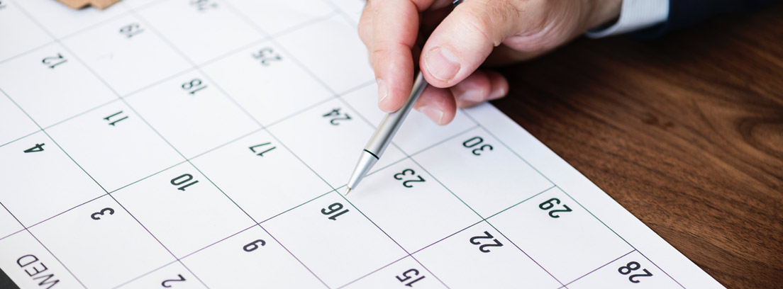 Hoja de calendario con días laborales y naturales sobre la que apunta un bolígrafo