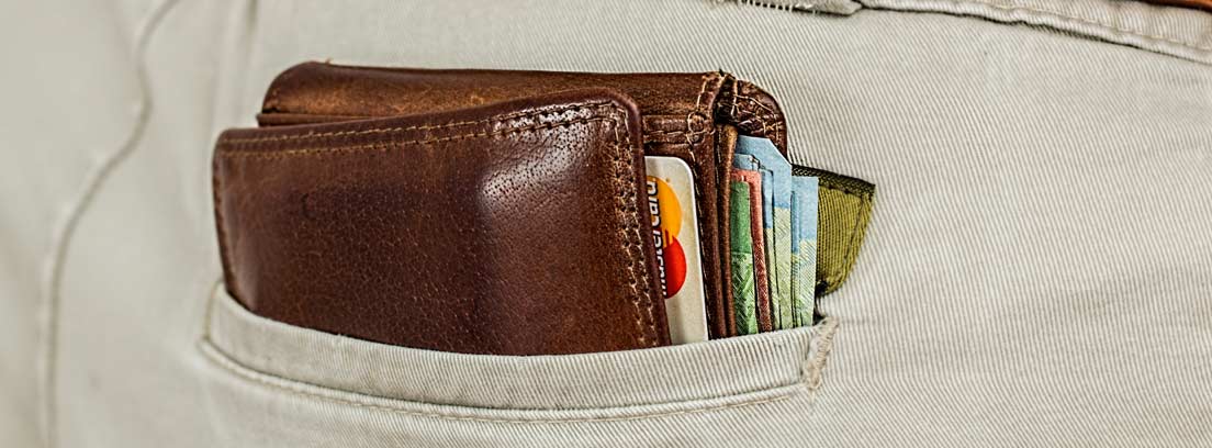 Vista parcial del bolsillo de un pantalón con una cartera repleta de billetes
