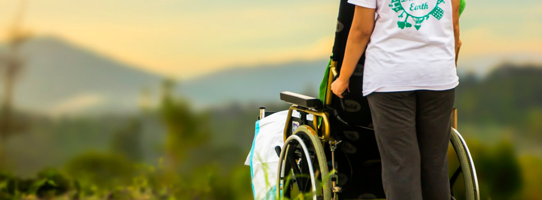 Persona llevando una silla de ruedas