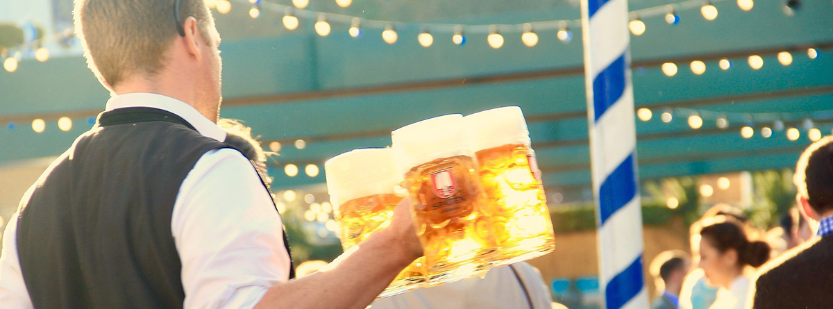 Camarero llevando tres jarras de cerveza