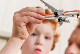 Hombre y niño jugando con un avión de juguete