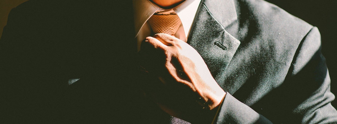 Hombre ajustándose la corbata del traje