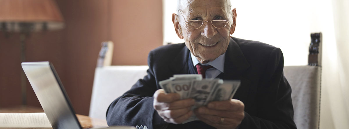 Hombre mayor sosteniendo unos billetes