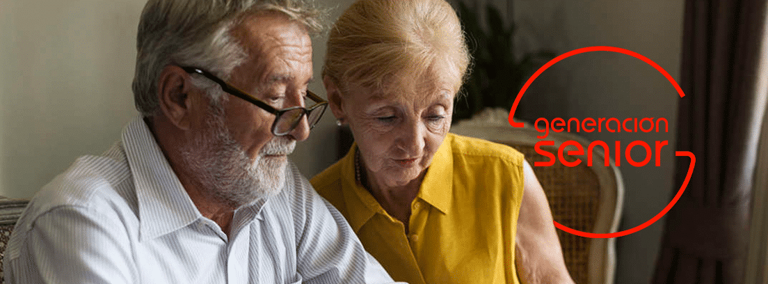 Cuanto se r3educe la jubilación anticipada: pareja de senior sentados mirando papeles