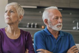 Dos personas mayores con cara de enfadados mirando uno hacia cada lado