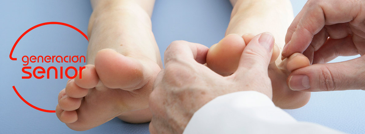 Manos de un podólogo haciendo un tratamiento en unos pies