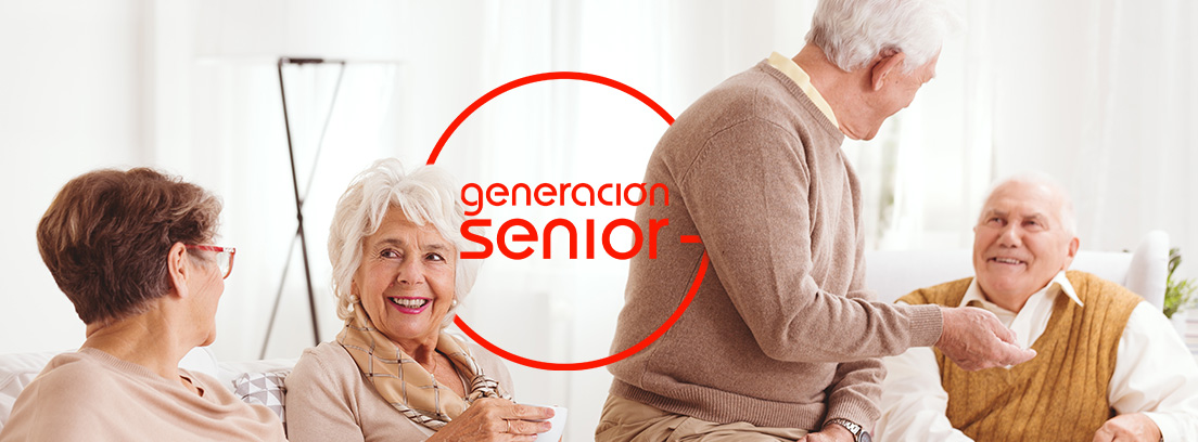 Personas mayores sonrientes sentados en un sofá con tazas de café