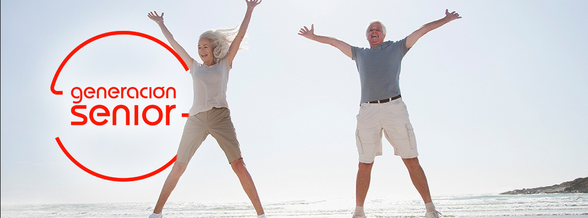 : Mujer y hombre mayores saltando en la playa