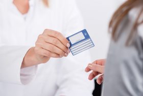 Médico entregando una tarjeta a una paciente