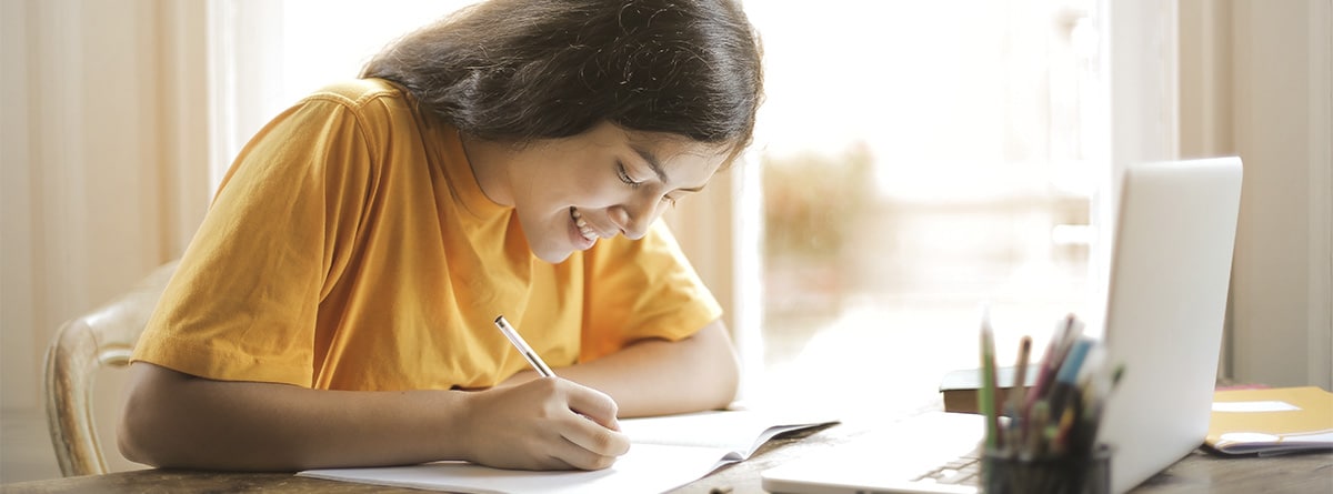 Chica joven escribiendo frente a un ordenador