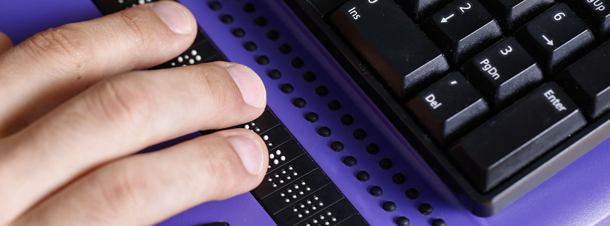 Persona ciega usando un teclado con braille