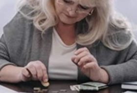 Mujer contando monedas sobre una mesa