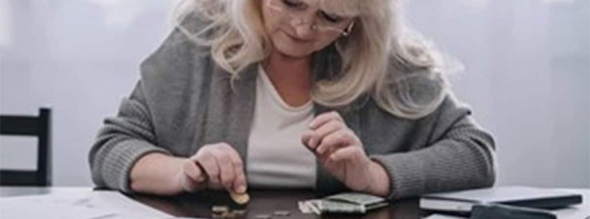 Mujer contando monedas sobre una mesa