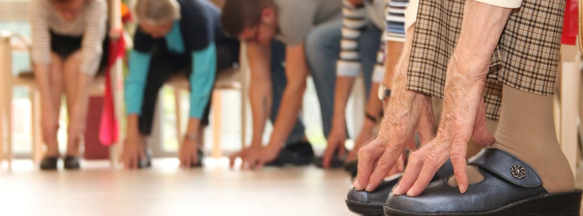 Varias personas mayores hacen ejercicios de flexibilidad