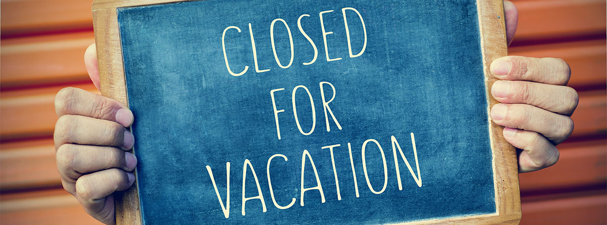 Pizarra con cartel de “cerrado por vacaciones”