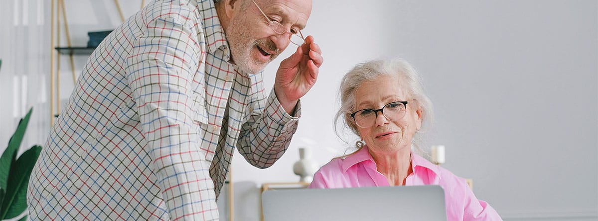 Pareja de personas mayores mirando un ordenador