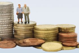 Figuras de 2 ancianos sobre varios montones de monedas.