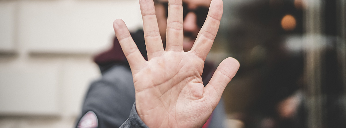 Persona mostrando una mano como señal de stop