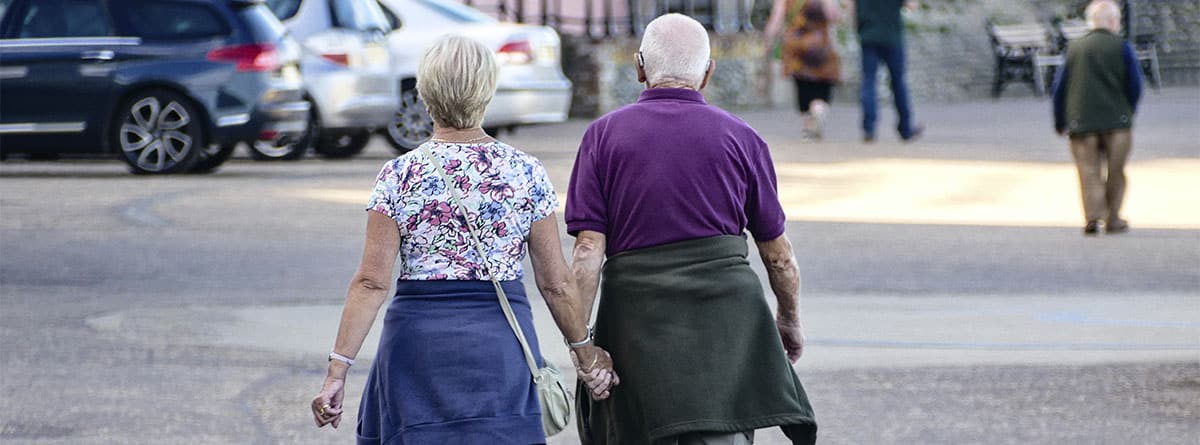 Dos personas mayores caminando de la mano