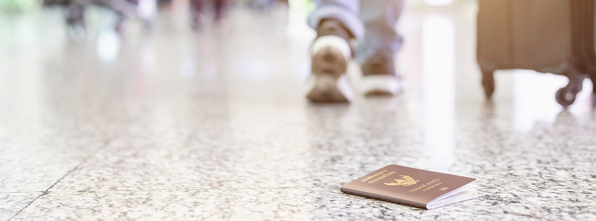Una persona se aleja de un pasaporte tirado en el suelo.
