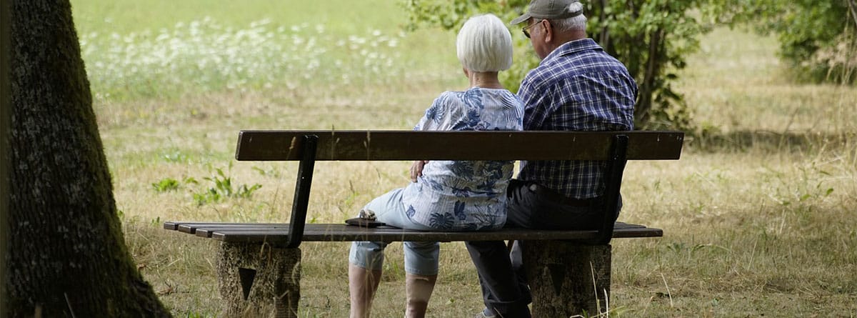 Dos personas mayores sentadas en un banco