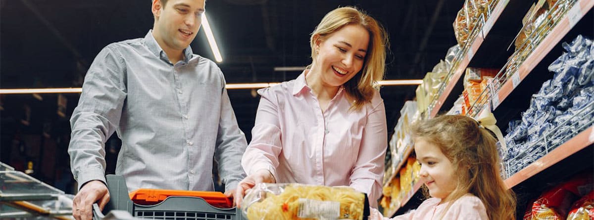 Una pareja y una niña comprando en un supermercado.