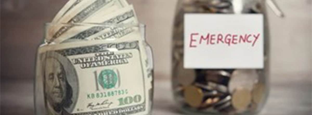 Un bote de cristal con billetes y otro con monedas y la palabra “Emergency”.