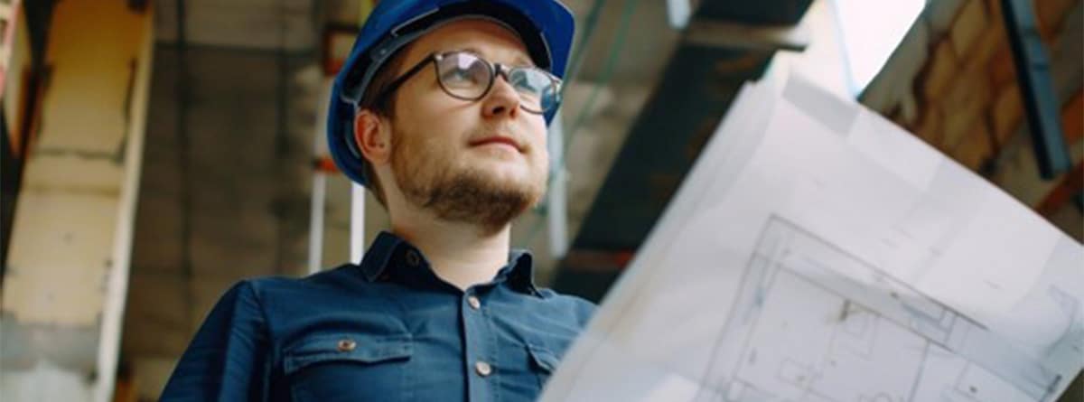 Hombre con casco construccion mirando un plano 