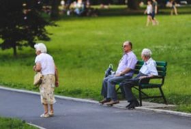 Señores mayores sentados y caminando en un parque