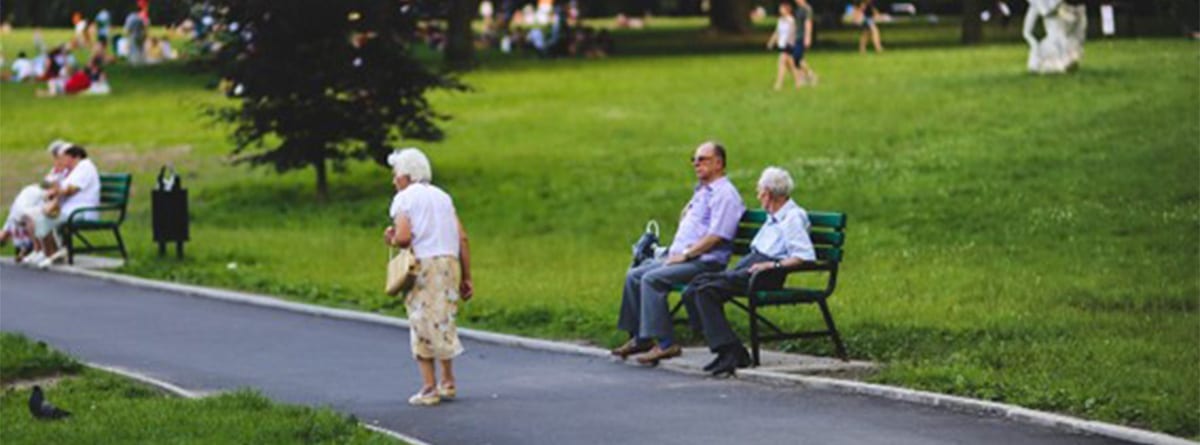 Señores mayores sentados y caminando en un parque